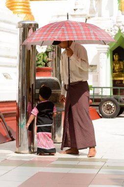Yangon, Myanmar - 24 Ağustos 2016: Yerel bir tapınakta tanımlanamayan Birmanyalı baba ve kızı. Myanma halkının yüzde 68'i Bamar etnik grubuna mensandı