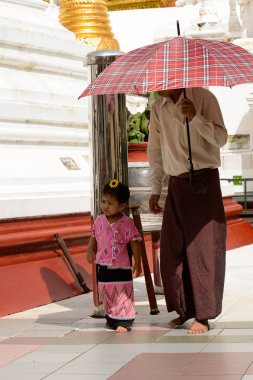 Yangon, Myanmar - 24 Ağustos 2016: Yerel bir tapınakta tanımlanamayan Birmanyalı baba ve kızı. Myanma halkının yüzde 68'i Bamar etnik grubuna mensandı