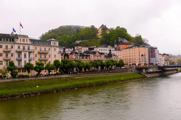 Salzburg, Avusturya - 1 Mayıs 2016: Salzburg nehri kıyısındaki evler, Avusturya. Avusturya'nın dördüncü büyük şehridir.