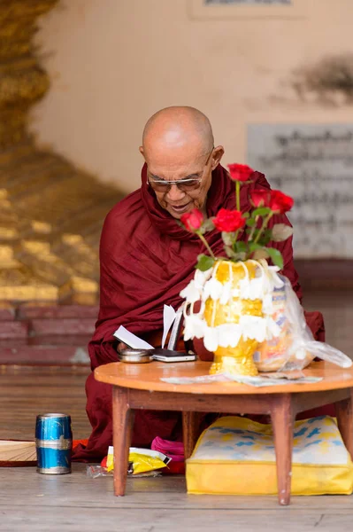 Yangon, Myanmar - 24 Ağustos 2016: Tanımlanamayan Birmanyalı Budist keşiş tapınakta kitap okuyor. Myanma halkının yüzde 68'i Bamar etnik grubuna mensandı