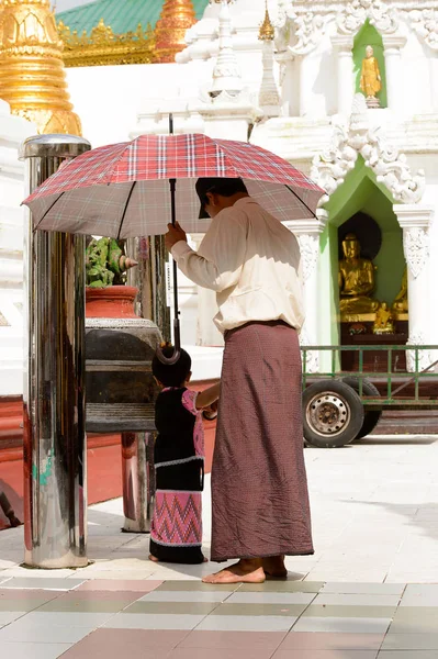 Yangon, Myanmar - 24 Ağustos 2016: Yerel bir tapınakta tanımlanamayan Birmanyalı baba ve kızı. Myanma halkının yüzde 68'i Bamar etnik grubuna mensandı