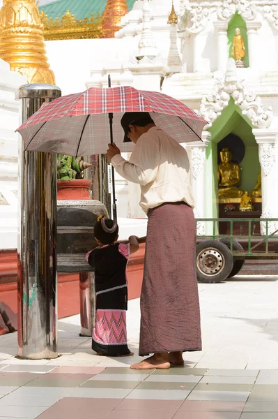 Yangon, Myanmar - 24 Ağustos 2016: Yerel bir tapınakta tanımlanamayan Birmanyalı baba ve kızı. Myanma halkının yüzde 68'i Bamar etnik grubuna mensandı
