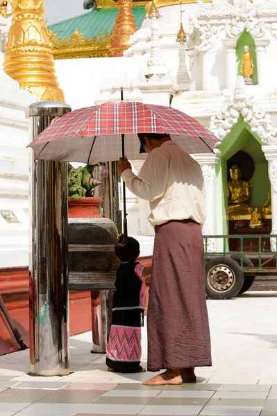 Yangon, Myanmar - 24 Ağustos 2016: Yerel bir tapınakta tanımlanamayan Birmanyalı baba ve kızı. Myanma halkının yüzde 68'i Bamar etnik grubuna mensandı