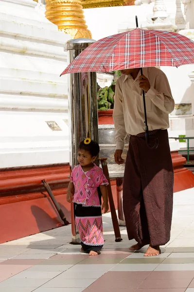 Yangon, Myanmar - 24 Ağustos 2016: Yerel bir tapınakta tanımlanamayan Birmanyalı baba ve kızı. Myanma halkının yüzde 68'i Bamar etnik grubuna mensandı