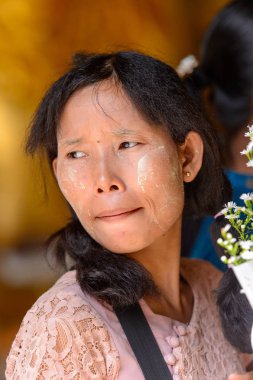 Yangon, Myanmar - 24 Ağustos 2016: Bir tapınakta boyalı yüzü olan kimliği belirsiz Birmanyalı kadın. Myanma halkının yüzde 68'i Bamar etnik grubuna mensandı