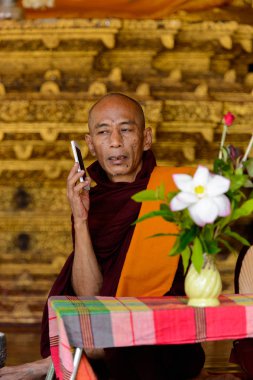 Yangon, Myanmar - 24 Ağustos 2016: Tanımlanamayan Birmanyalı Budist keşiş telefonda konuşuyor. Myanma halkının yüzde 68'i Bamar etnik grubuna mensandı