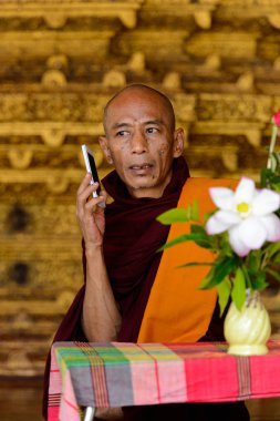 Yangon, Myanmar - 24 Ağustos 2016: Tanımlanamayan Birmanyalı Budist keşiş telefonda konuşuyor. Myanma halkının yüzde 68'i Bamar etnik grubuna mensandı