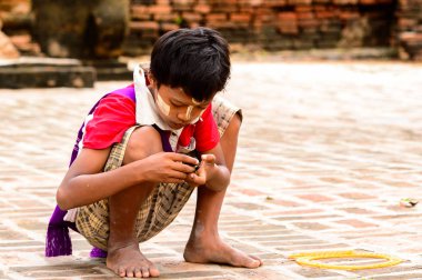 Inwa, Myanmar - 25 Ağustos 2016: Tanımlanamayan Birmanyalı genç çocuk yerde oynuyor. Myanma halkının yüzde 68'i Bamar etnik grubuna mensandı