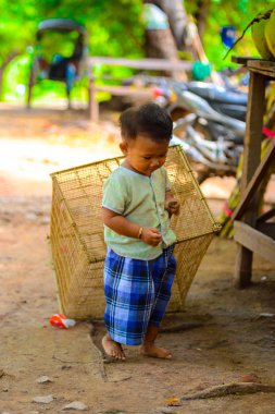 Inwa, Myanmar - 25 Ağustos 2016: Kimliği belirsiz Birmanyalı çocuk kafesi çekiyor. Myanma halkının yüzde 68'i Bamar etnik grubuna mensandı