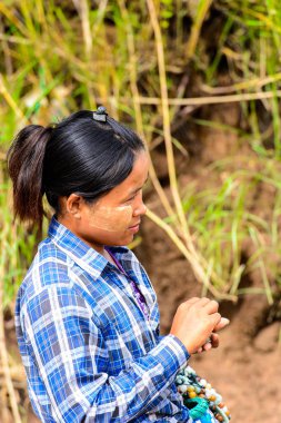 Inwa, Myanmar - 25 Ağustos 2016: Tanımlanamayan Birmanyalı kız satılık hediyelik eşya lar sunuyor. Myanma halkının yüzde 68'i Bamar etnik grubuna mensandı