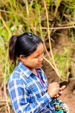 Inwa, Myanmar - 25 Ağustos 2016: Tanımlanamayan Birmanyalı kız satılık hediyelik eşya lar sunuyor. Myanma halkının yüzde 68'i Bamar etnik grubuna mensandı