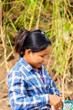 Inwa, Myanmar - 25 Ağustos 2016: Tanımlanamayan Birmanyalı kız satılık hediyelik eşya lar sunuyor. Myanma halkının yüzde 68'i Bamar etnik grubuna mensandı