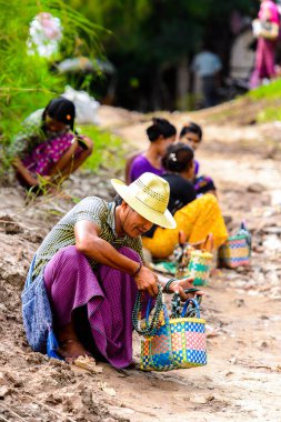 Inwa, Myanmar - 25 Ağustos 2016: Tanımlanamayan Birmanyalı adam satılık hediyelik eşya lar sunuyor. Myanma halkının yüzde 68'i Bamar etnik grubuna mensandı
