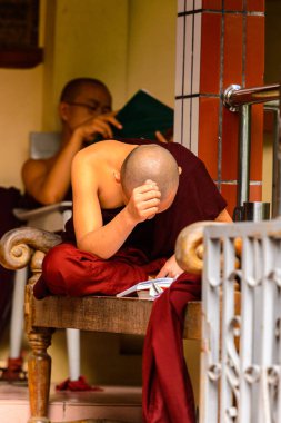 Inwa, Myanmar - 25 Ağustos 2016: Tanımlanamayan Birmanyalı Budist keşiş bir kitap okuyor. Myanma halkının yüzde 68'i Bamar etnik grubuna mensandı