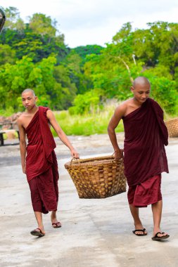 Inwa, Myanmar - 25 Ağustos 2016: Tanımlanamayan Birmanyalı Budist rahipler bir sepet taşıyor. Myanma halkının yüzde 68'i Bamar etnik grubuna mensandı