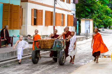 Inwa, Myanmar - 25 Ağustos 2016: Sokakta arabası olan kimliği belirsiz Birmanyalı genç Budist rahipler. Myanma halkının yüzde 68'i Bamar etnik grubuna mensandı