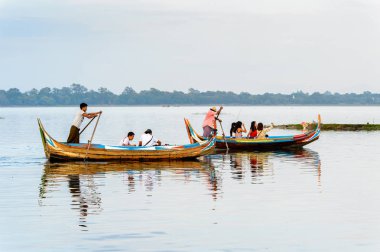 Taungthaman Gölü, Myanmar - 25 Ağustos 2016: Kimliği belirsiz Birmanyalı adam, Myanmar'ın eski başkenti Amarapura yakınlarındaki Taungthaman Gölü üzerinde turistlerle birlikte bir tekneyle yelken açtı