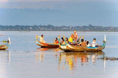 Taungthaman Gölü, Myanmar - 25 Ağustos 2016: Kimliği belirsiz Birmanyalı adam, Myanmar'ın eski başkenti Amarapura yakınlarındaki Taungthaman Gölü üzerinde turistlerle birlikte bir tekneyle yelken açtı