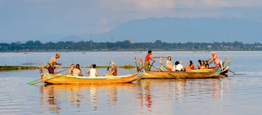 Taungthaman Gölü, Myanmar - 25 Ağustos 2016: Kimliği belirsiz Birmanyalı adam, Myanmar'ın eski başkenti Amarapura yakınlarındaki Taungthaman Gölü üzerinde turistlerle birlikte bir tekneyle yelken açtı