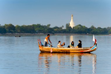 Taungthaman Gölü, Myanmar - 25 Ağustos 2016: Kimliği belirsiz Birmanyalı adam, Myanmar'ın eski başkenti Amarapura yakınlarındaki Taungthaman Gölü üzerinde turistlerle birlikte bir tekneyle yelken açtı