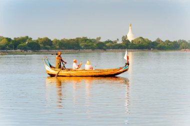 Taungthaman Gölü, Myanmar - 25 Ağustos 2016: Kimliği belirsiz Birmanyalı adam, Myanmar'ın eski başkenti Amarapura yakınlarındaki Taungthaman Gölü üzerinde turistlerle birlikte bir tekneyle yelken açtı