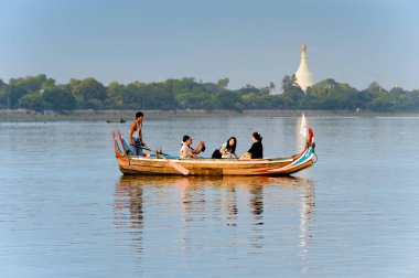 Taungthaman Gölü, Myanmar - 25 Ağustos 2016: Kimliği belirsiz Birmanyalı adam, Myanmar'ın eski başkenti Amarapura yakınlarındaki Taungthaman Gölü üzerinde turistlerle birlikte bir tekneyle yelken açtı