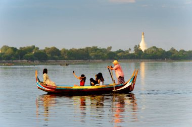 Taungthaman Gölü, Myanmar - 25 Ağustos 2016: Kimliği belirsiz Birmanyalı adam, Myanmar'ın eski başkenti Amarapura yakınlarındaki Taungthaman Gölü üzerinde turistlerle birlikte bir tekneyle yelken açtı