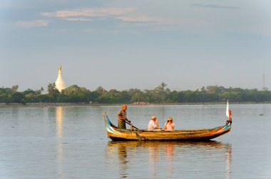 Taungthaman Gölü, Myanmar - 25 Ağustos 2016: Kimliği belirsiz Birmanyalı adam, Myanmar'ın eski başkenti Amarapura yakınlarındaki Taungthaman Gölü üzerinde turistlerle birlikte bir tekneyle yelken açtı