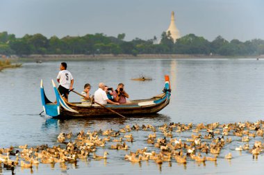 Taungthaman Gölü, Myanmar - 25 Ağustos 2016: Kimliği belirsiz Birmanyalı adam, Myanmar'ın eski başkenti Amarapura yakınlarındaki Taungthaman Gölü üzerinde turistlerle birlikte bir tekneyle yelken açtı