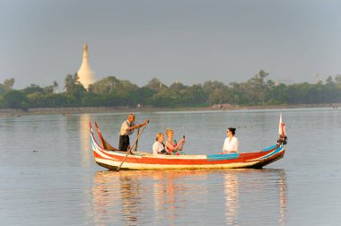 Taungthaman Gölü, Myanmar - 25 Ağustos 2016: Kimliği belirsiz Birmanyalı adam, Myanmar'ın eski başkenti Amarapura yakınlarındaki Taungthaman Gölü üzerinde turistlerle birlikte bir tekneyle yelken açtı
