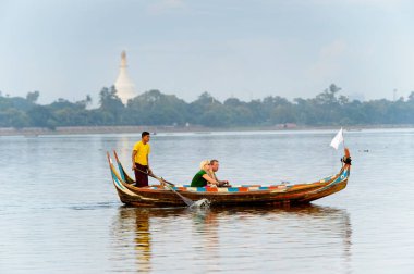 Taungthaman Gölü, Myanmar - 25 Ağustos 2016: Myanmar'ın eski başkenti Amarapura yakınlarındaki Taungthaman Gölü üzerinde seyreden bir teknedeki kimliği belirsiz Birmanyalı adam