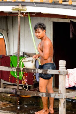 Mandalay, Myanmar - 26 Ağustos 2016: Tanımlanamayan Birmanyalı çocuk duş için bir kova su kullanıyor. Myanma halkının yüzde 68'i Bamar etnik grubuna mensandı