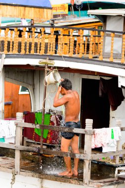 Mandalay, Myanmar - 26 Ağustos 2016: Tanımlanamayan Birmanyalı çocuk duş için bir kova su kullanıyor. Myanma halkının yüzde 68'i Bamar etnik grubuna mensandı