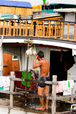 Mandalay, Myanmar - 26 Ağustos 2016: Tanımlanamayan Birmanyalı çocuk duş için bir kova su kullanıyor. Myanma halkının yüzde 68'i Bamar etnik grubuna mensandı