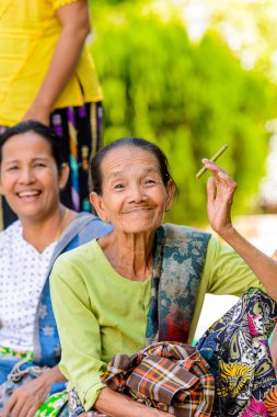 Mingun, Myanmar - 26 Ağustos 2016: Bir tapınakta sigara içen kimliği belirsiz Birmanyalı kadın. Myanma halkının yüzde 68'i Bamar etnik grubuna mensandı