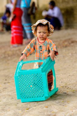 Mingun, Myanmar - 26 Ağustos 2016: Boyalı suratlı kimliği belirsiz Birmanyalı kız sokakta oynuyor. Myanma halkının yüzde 68'i Bamar etnik grubuna mensandı