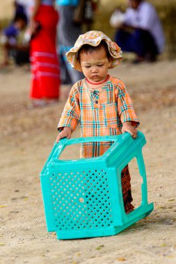 Mingun, Myanmar - 26 Ağustos 2016: Boyalı suratlı kimliği belirsiz Birmanyalı kız sokakta oynuyor. Myanma halkının yüzde 68'i Bamar etnik grubuna mensandı