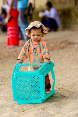 Mingun, Myanmar - 26 Ağustos 2016: Boyalı suratlı kimliği belirsiz Birmanyalı kız sokakta oynuyor. Myanma halkının yüzde 68'i Bamar etnik grubuna mensandı
