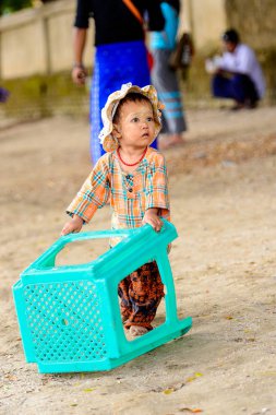 Mingun, Myanmar - 26 Ağustos 2016: Boyalı suratlı kimliği belirsiz Birmanyalı kız sokakta oynuyor. Myanma halkının yüzde 68'i Bamar etnik grubuna mensandı