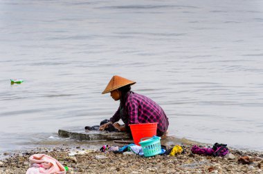 Irrawaddy Nehri, Myanmar - 26 Ağustos 2016: Kimliği belirsiz Birmanyalı kız, Myanmar'ın Irrawaddy Nehri'ndeki giysilerini temizliyor. Bu en büyük rive ve en önemli ticari su yolu