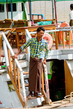 Mingun, Myanmar - 26 Ağustos 2016: Ahşap teknenin yanında kimliği belirsiz bir manya, biradam. Myanma halkının yüzde 68'i Bamar etnik grubuna mensandı