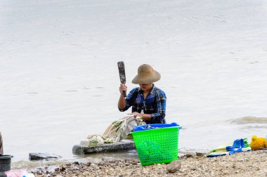 Irrawaddy Nehri, Myanmar - 26 Ağustos 2016: Kimliği belirsiz Birmanyalı kız, Myanmar'ın Irrawaddy Nehri'ndeki giysilerini temizliyor. Bu en büyük rive ve en önemli ticari su yolu