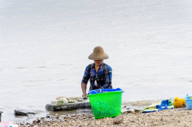Irrawaddy Nehri, Myanmar - 26 Ağustos 2016: Kimliği belirsiz Birmanyalı kız, Myanmar'ın Irrawaddy Nehri'ndeki giysilerini temizliyor. Bu en büyük rive ve en önemli ticari su yolu