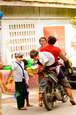 Mandalay, Myanmar - 26 Ağustos 2016: Motosikletli kimliği belirsiz bir manyacık çocuk. Myanma halkının yüzde 68'i Bamar etnik grubuna mensandı