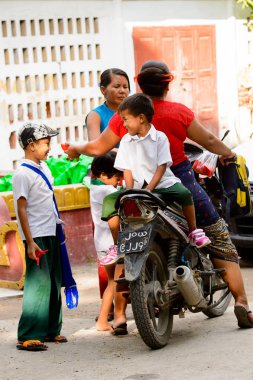 Mandalay, Myanmar - 26 Ağustos 2016: Motosikletli kimliği belirsiz bir manyacık çocuk. Myanma halkının yüzde 68'i Bamar etnik grubuna mensandı