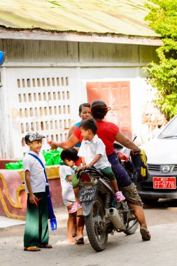 Mandalay, Myanmar - 26 Ağustos 2016: Motosikletli kimliği belirsiz bir manyacık çocuk. Myanma halkının yüzde 68'i Bamar etnik grubuna mensandı