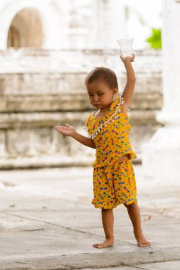 Mandalay, Myanmar - 26 Ağustos 2016: Tanımlanamayan Birmanyalı küçük kız sokakta oynuyor. Myanma halkının yüzde 68'i Bamar etnik grubuna mensandı