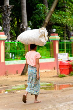 Bagan, Myanmar - 29 Ağustos 2016: Kimliği belirsiz Birmanyalı kadın haed üzerinde bir çanta taşıyor. Myanma halkının yüzde 68'i Bamar etnik grubuna mensandı