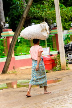 Bagan, Myanmar - 29 Ağustos 2016: Kimliği belirsiz Birmanyalı kadın haed üzerinde bir çanta taşıyor. Myanma halkının yüzde 68'i Bamar etnik grubuna mensandı