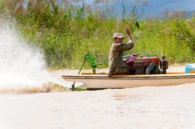 Inle Lake, Myanmar - 30 Ağustos 2016: Myanmar'ın Shan Eyaletinin Taunggyi İlçesi'nin Nyaungshwe İlçesi'nde bulunan bir tatlı su gölü olan Inle Sap'ın üzerinde bambu teknede bulunan tanımlanamayan Birmanyalı adam